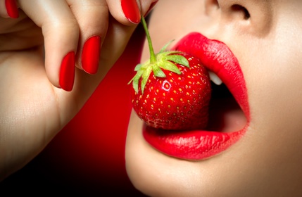 Sexy Woman Eating Strawberry. Sensual Red Lips